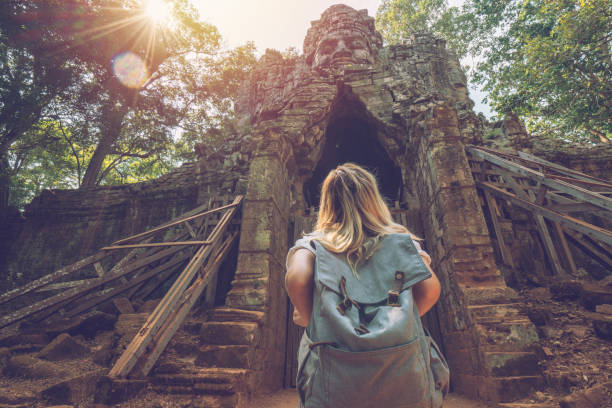 mujer viaje turístico parado frente a complejo puerta del templo mirando la escultura en la parte superior, concepto de exploración de descubrimiento de personas - angkor ancient architecture asia fotografías e imágenes de stock