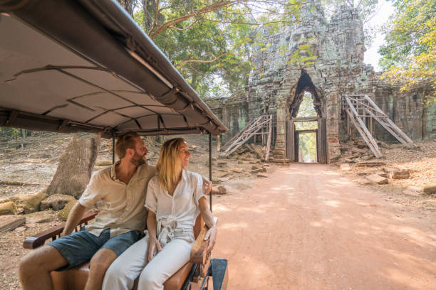 istock Young couple riding rickshaw in ancient temple complex city 961254142