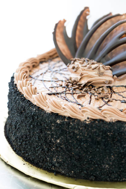 istock Chocolate brown cake with biscuit crumbs, chocolate leaves and walnuts 961256706