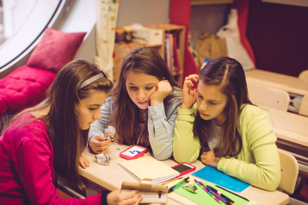 istock Teenage girls using mobile phone in class 961256772