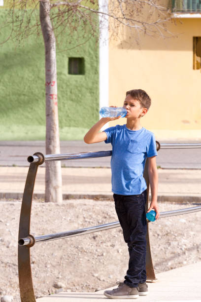 istock Boy drinks water from a bottle outdoors 961260680