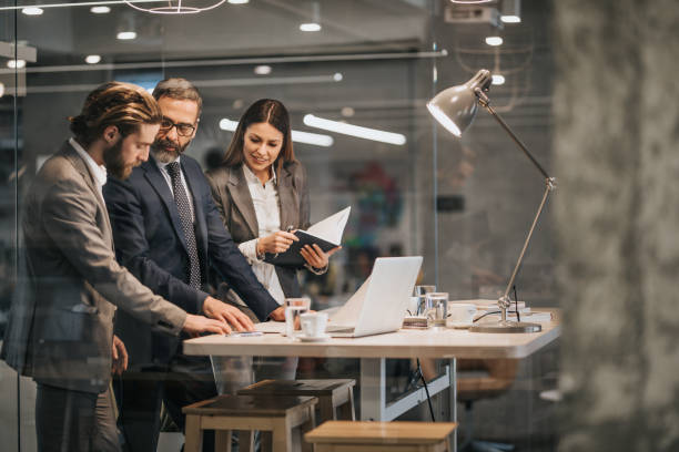 istock Group of business people communicating while working on blueprints in the office. 961261426