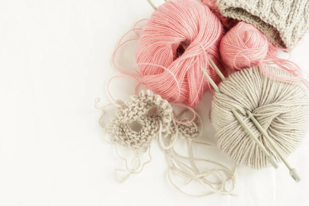 istock Grey and pink  knitting wool and knitting needles on white background. top view.copy space.Close up 961269952