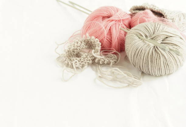 istock Grey and pink  knitting wool and knitting needles on white background. top view.copy space.Close up 961270312