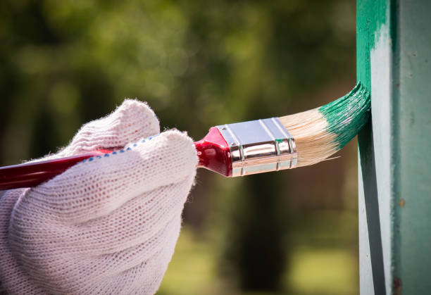 istock Man wearing gloves paint metal surface with a brush 961270552