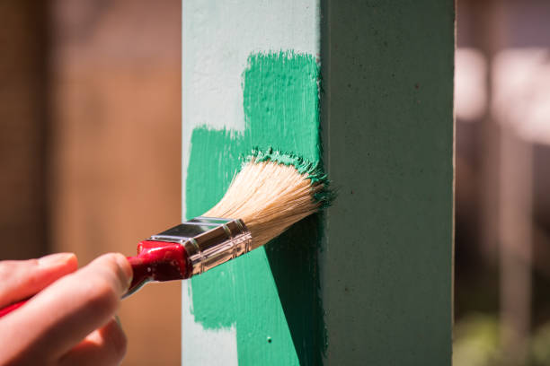istock Man wearing gloves paint metal surface with a brush 961270686
