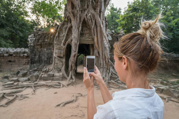 istock Tourist female exploring ancient temples and taking smart phone pictures 961274374