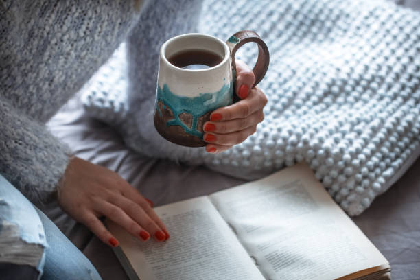 istock girl holds a cup and reads book 961278380