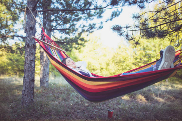 istock Young woman relaxing in a hammock 961285130