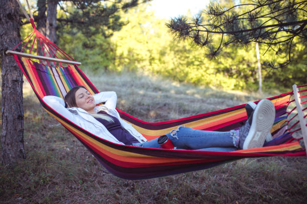 istock Young woman relaxing in a hammock 961285226