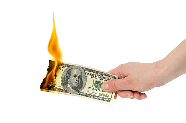 burning dollar in hand stock photo