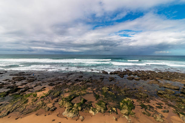 istock Rocky Beach Waves and Ocean Against Blue Cloudy Skyline 961296162