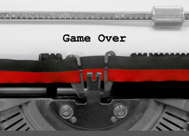 istock Game Over by the old typewriter on white paper 961303434