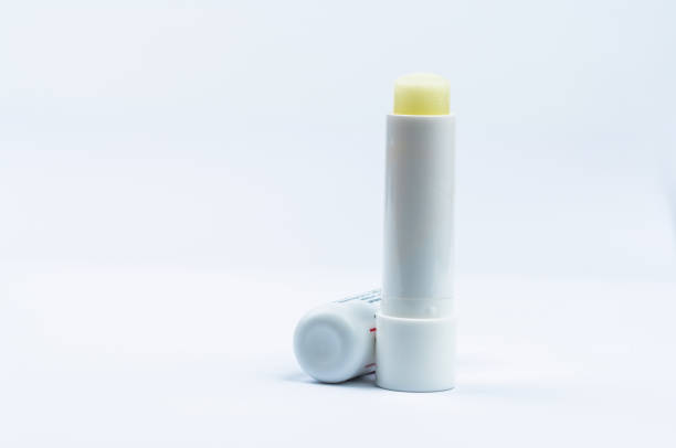 istock Lip balm for dry, sensitive lips. Opened cap lip care isolated on white background. Lip balm with SPF 15. for rough lip and UV protection. Lipstick for treatment dehydrated and chapped lips. Skincare 961303442