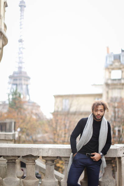 istock Half american nigerian man standing near concrete railing with Eiffel Tower background in Paris 961303524