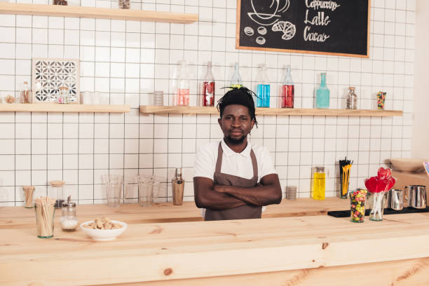 istock african american bartender with crossed arms standing at bar counter 961304624