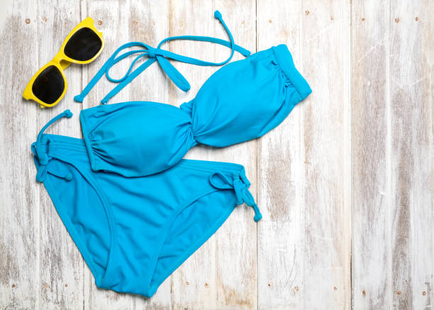 plat poser des éléments de l’été avec bikini coloré et accessoires sur fond en bois blanc, le concept de l’été, l’espace de copie - maillot de bain photos et images de collection