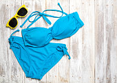 Flat lay of summer items with colorful bikini and accessories on white wooden background, Summer concept, Copy space