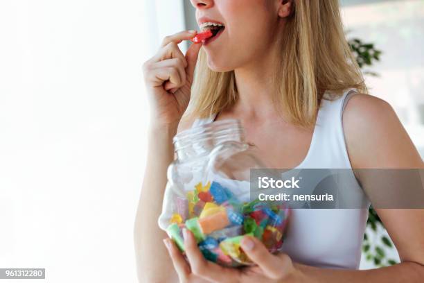 Pretty Young Woman Eating Colorful Jelly Candies At Home Addiction Concept Stock Photo - Download Image Now
