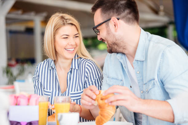 istock Happy young couple eating breakfast in a cafe 961324118