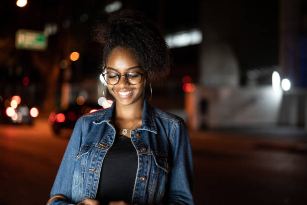 istock Young black woman with afro hairstyle using mobile in urban background 961336348