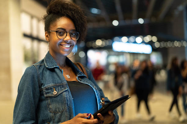 istock Young black woman with afro hairstyle using digital tablet in urban background 961336474