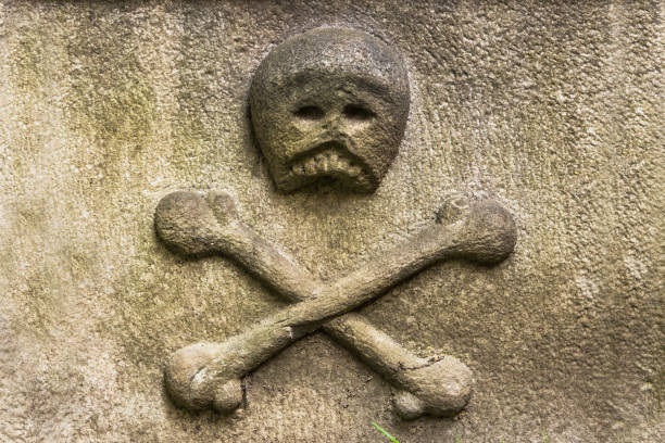 istock Skull and crossed bones carved on an old stone 961344092