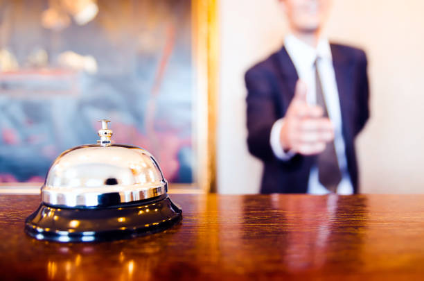 Hotel reception bell and receptionist greeting handshake