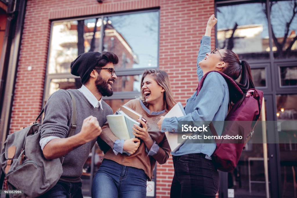 Yes ! We passed ! Group of students standing outdoors cheering University Student Stock Photo