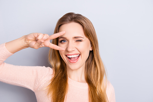 Open mouth people person entertainment concept. Close up portrait of playful excited funny joyful positive optimistic with toothy smile girl showing v-sign isolated on gray background copy-space