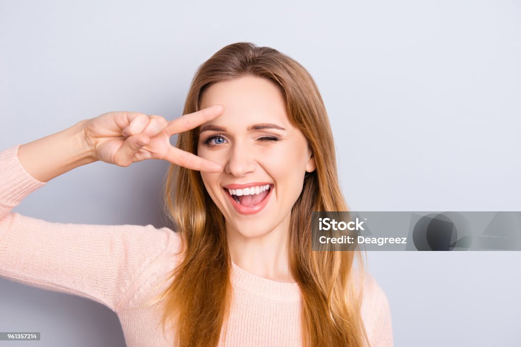 Open mouth people person entertainment concept. Close up portrait of playful excited funny joyful positive optimistic with toothy smile girl showing v-sign isolated on gray background copy-space Eye Stock Photo