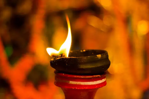 lit clay lamp on top of a clay stand or worship idol durgapuja india diwali