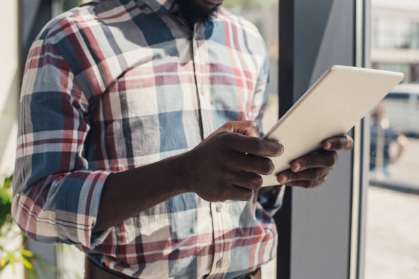 istock cropped view of african american man using digital tablet 961361106
