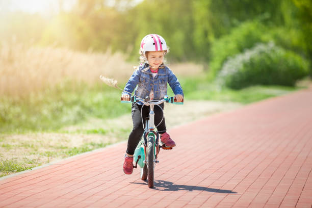 istock Cure little girl riding on bicycle 961365152
