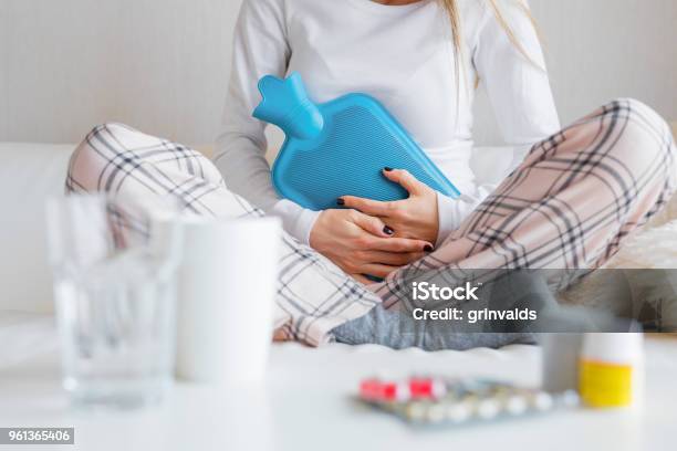 Mujer Con Bolsa De Agua Caliente Cura Dolor De Estómago Foto de stock y más banco de imágenes de Ciclo de menstruación