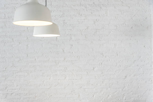 istock Vintage white bricks wall with white lamp in room. 961371402