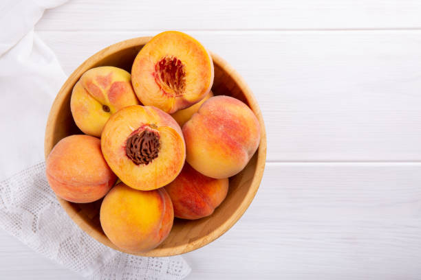 istock Ripe peaches close-up on a white wooden background. Top view. 961371862