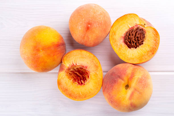 istock Ripe peaches close-up on a white wooden background. Top view. 961371868