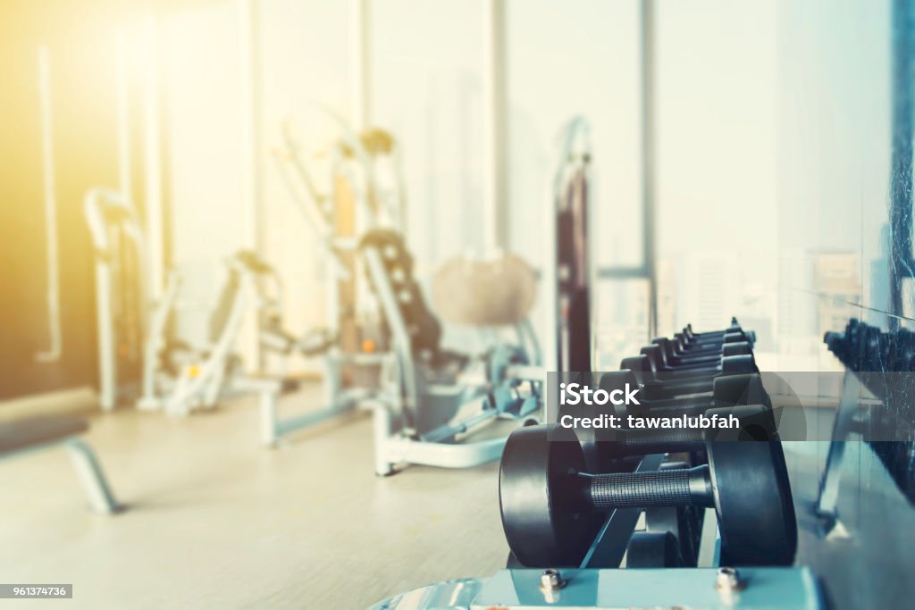 Fitness y fondo sano concepto. Pesas con borrosa fondo club gimnasio o deporte al atardecer. Cuadro para agregar mensajes de texto. Telón de fondo para obras de arte de diseño. - Foto de stock de Gimnasio libre de derechos