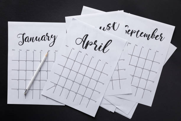 istock flat lay with paper calendar and pencil isolated on black 961375154