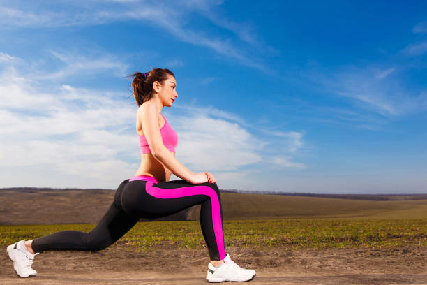 istock young woman doing exercises on blue sky background 961386044