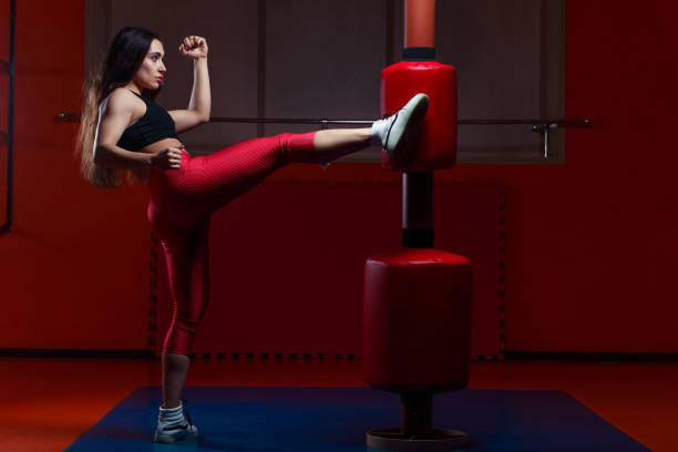 istock Woman kickboxing, hitting a punching dummy with a kick 961389282