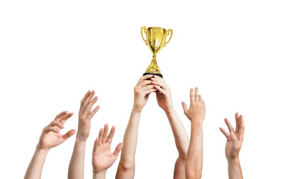 istock Many hands raised up. Winner is holding trophy in hands. Isolated on white background. 961399202