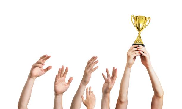 istock Many hands raised up. Winner is holding trophy in hands. Isolated on white background. 961399228