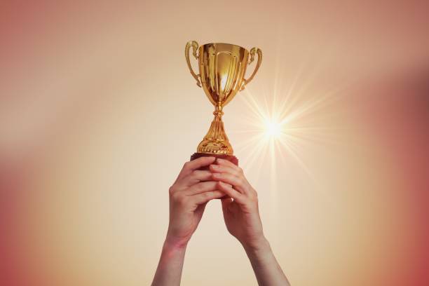 istock Winner is raised up a trophy in sunset. 961399516