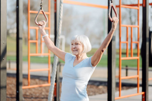 istock Exuberant old woman doing chin-ups 961399560