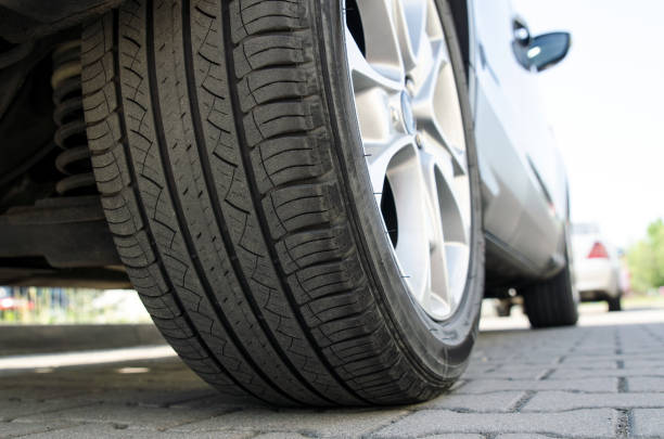 Car tire close up, parked car low angle shot Car all-season tire close up, parked car. Low angle shot, wheel auto with aluminum rim concept grooved stock pictures, royalty-free photos & images