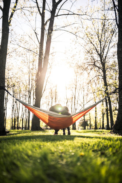 istock Mother and daughter in park relaxing in a hammock 961405620