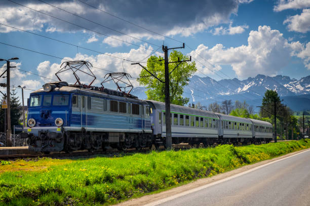 Passenger train at the railway station with Tatra mountains in the background, Poland