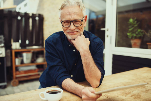 istock Smiling senior man relaxing on his patio using a tablet 961406668